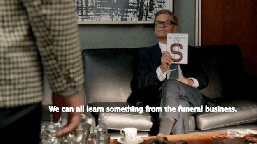 From Season 7, episode 3: Jim Cutler holds "The American Way of Death." From Styleite.com.